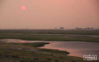 soleil couchant sur l'okavango au botswana en famille